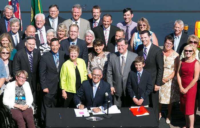 Gov. Jay Inslee signs Senate Bills 5987 (Relating to transportation revenue); 5988 (Relating to additive transportation funding and appropriations); and 5989 (Relating to authorizing bonds for transportation funding), during a ceremony at the University of Washington’s Conibear Shellhouse in Seattle, July 15, 2015.